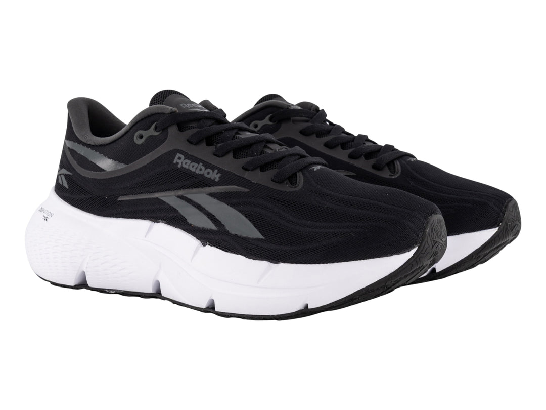 Tenis deportivos Reebok color negro con suela blanca y detalles laterales en gris.