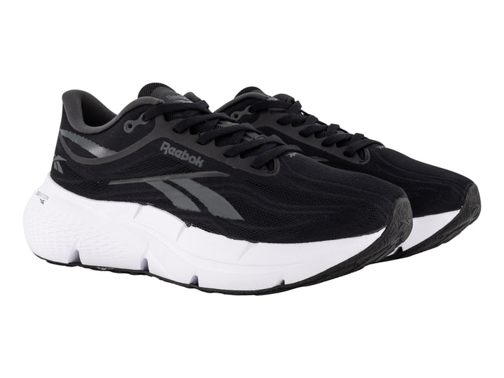 Tenis deportivos Reebok color negro con suela blanca y detalles laterales en gris.