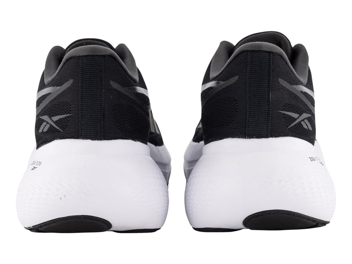 Tenis deportivos Reebok color negro con suela blanca y detalles laterales en gris.