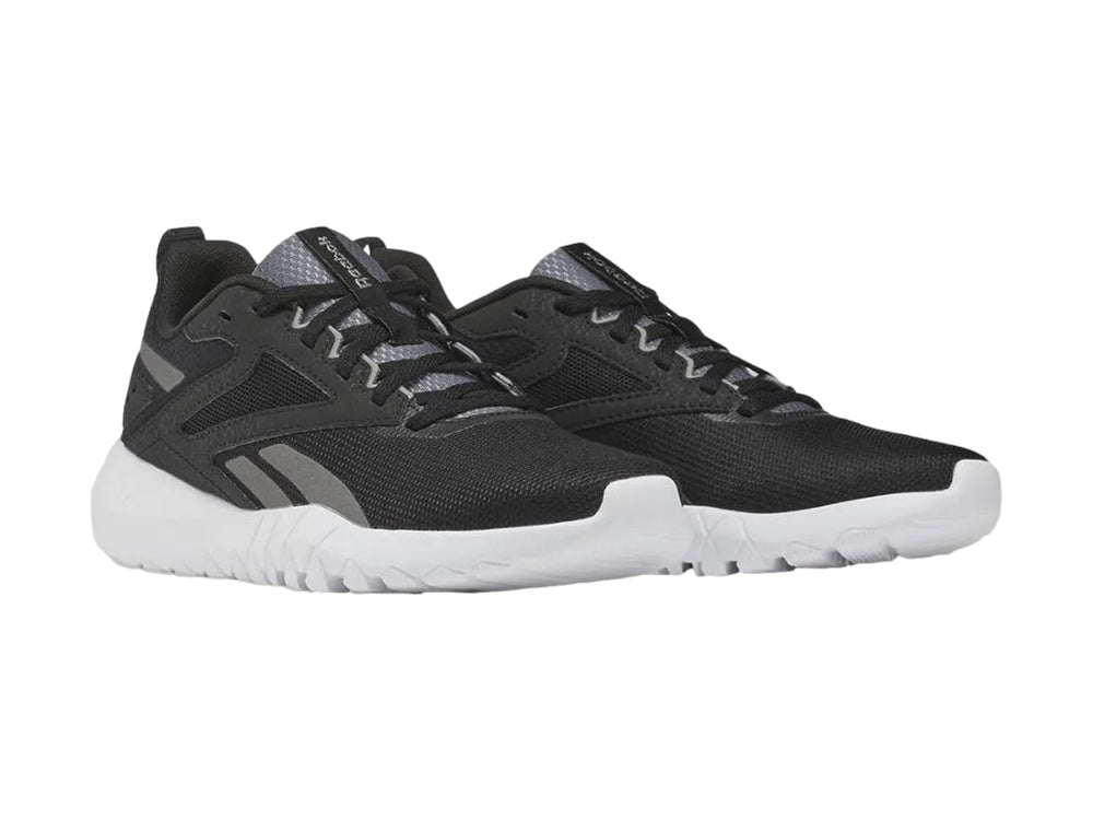 Tenis deportivos Reebok color negro con suela blanca y detalles en gris.