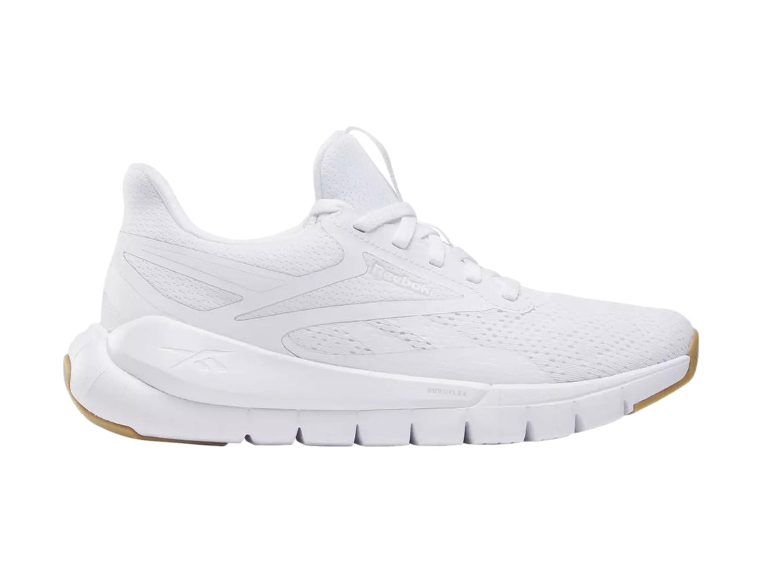 Tenis deportivos Reebok color blanco con suela de goma marrón.