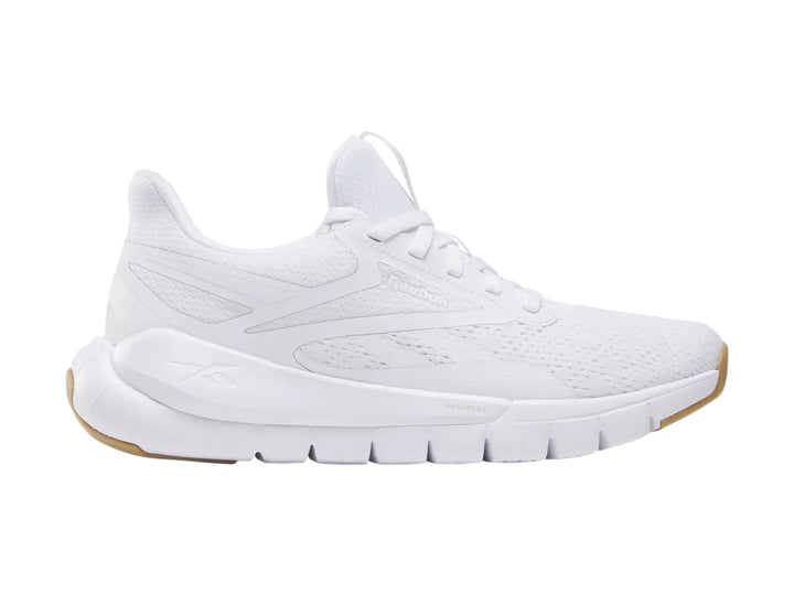 Tenis deportivos Reebok color blanco con suela de goma marrón.