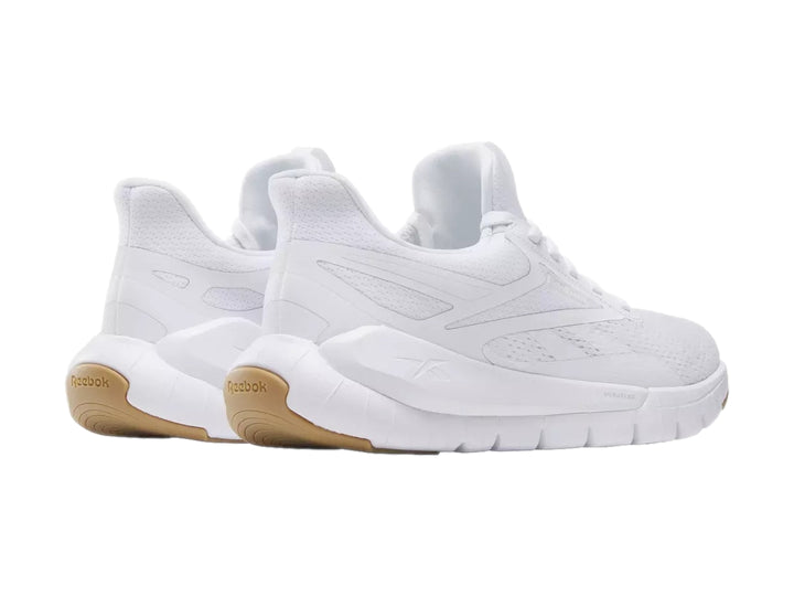 Tenis deportivos Reebok color blanco con suela de goma marrón.
