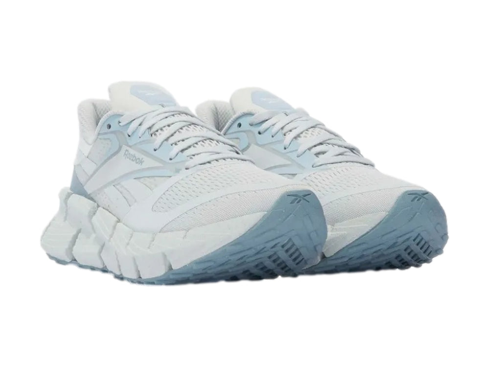 Tenis deportivos Reebok color azul claro con suela gruesa y malla transpirable.