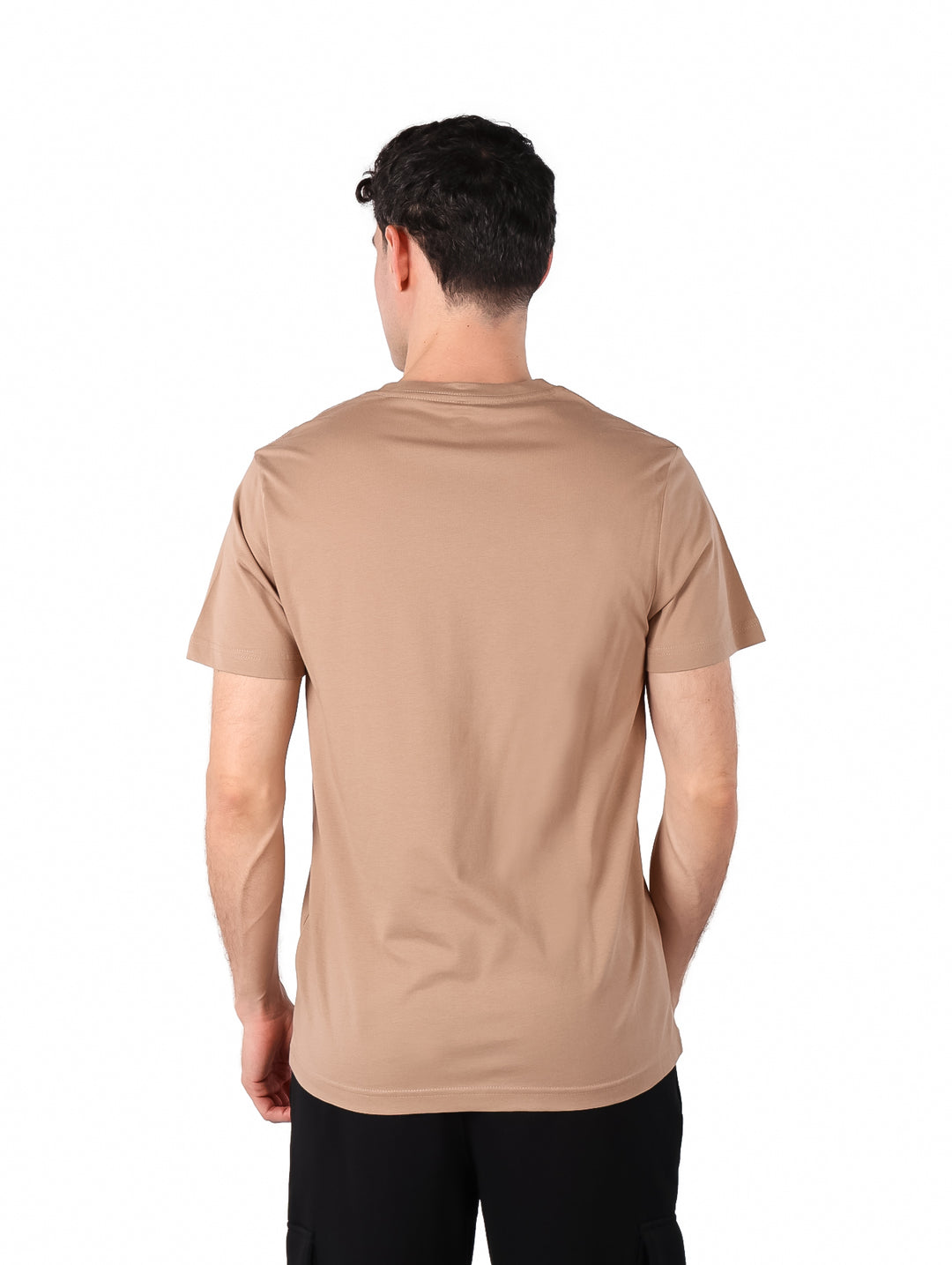 Hombre vistiendo una camiseta de manga corta color beige marca Hurley con logotipo pequeño en el pecho.