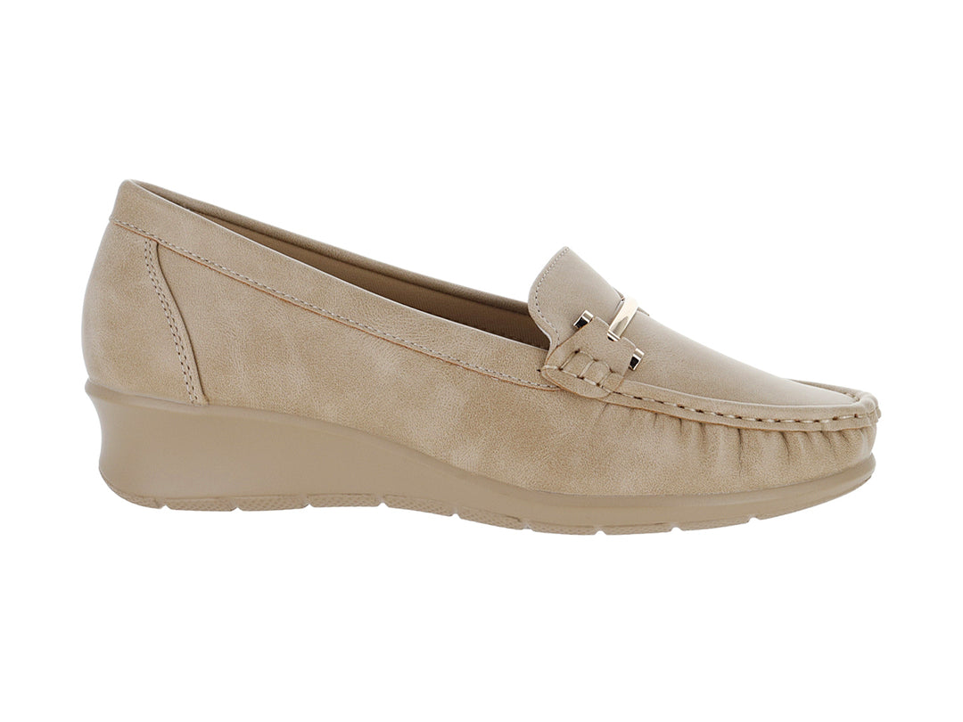 Zapato mocasín color beige con suela de cuña y detalle metálico frontal.