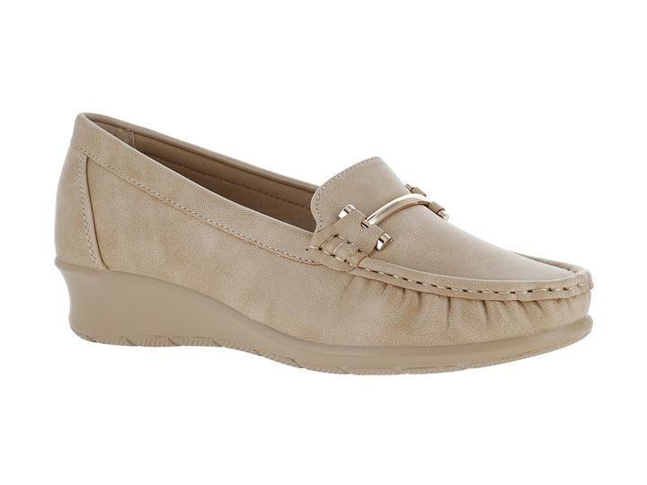 Zapato mocasín color beige con suela de cuña y detalle metálico frontal.