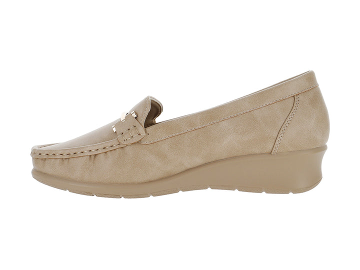 Zapato mocasín color beige con suela de cuña y detalle metálico frontal.