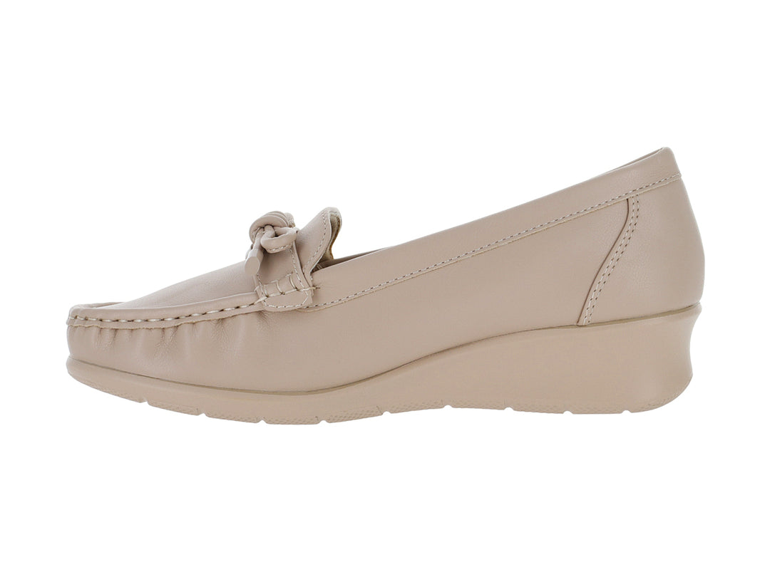 Zapato tipo mocasín color nude con suela de plataforma y detalle de lazo decorativo.