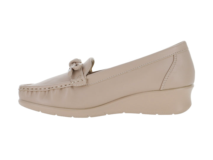 Zapato tipo mocasín color nude con suela de plataforma y detalle de lazo decorativo.