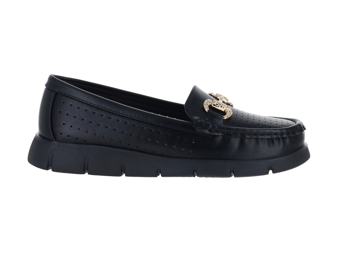 Zapato plano tipo mocasín color negro con adorno dorado y suela gruesa.