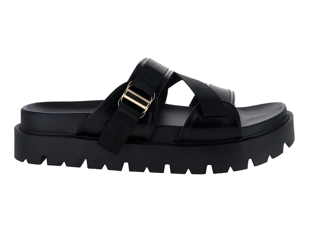 Sandalias negras de plataforma con suela dentada y correas ajustables con hebilla dorada.