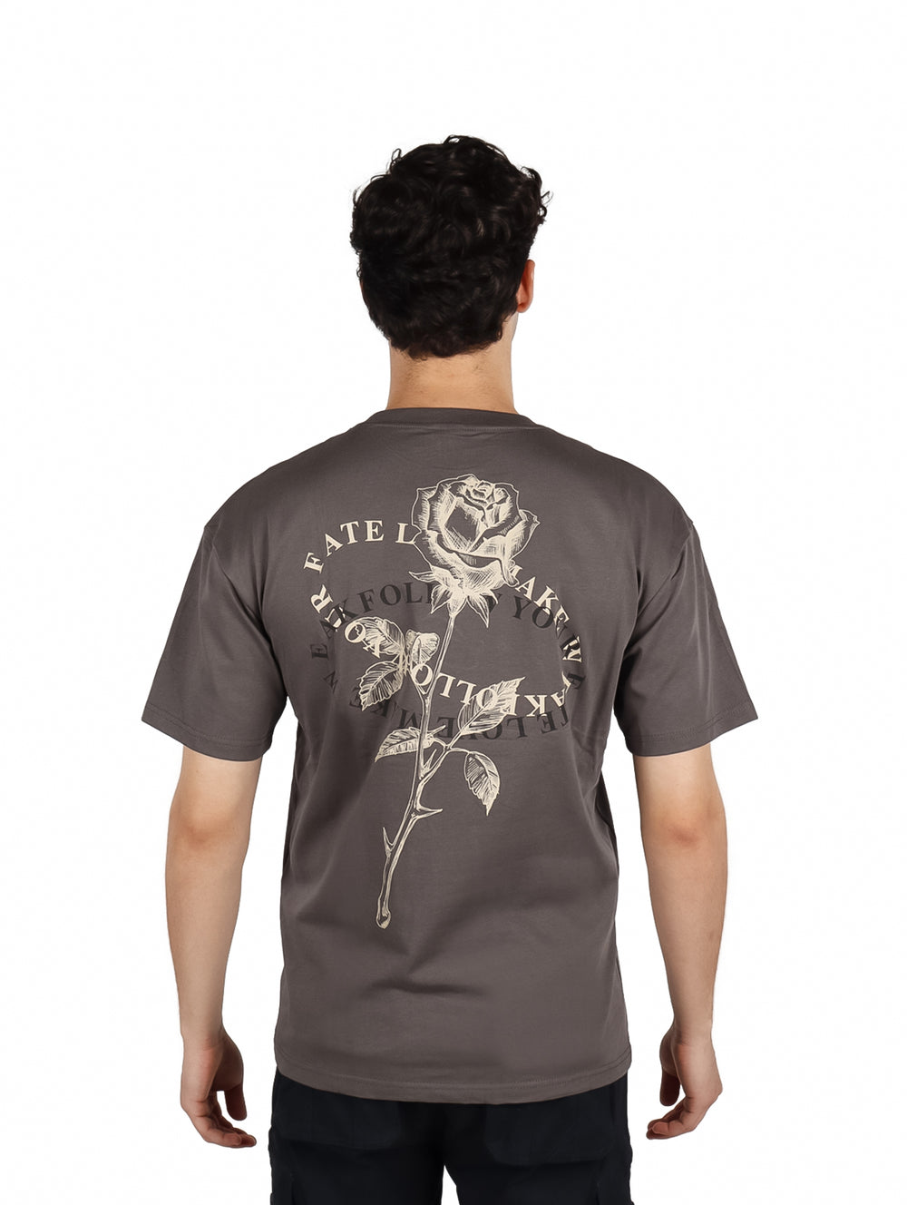 Hombre vistiendo playera gris oscuro de corte oversize con estampado blanco en el pecho.