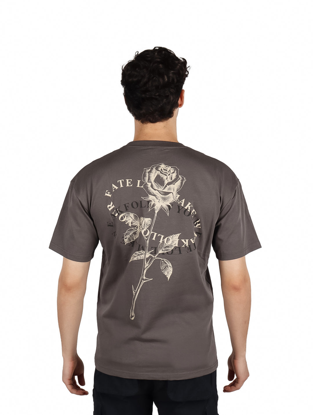 Hombre vistiendo playera gris oscuro de corte oversize con estampado blanco en el pecho.