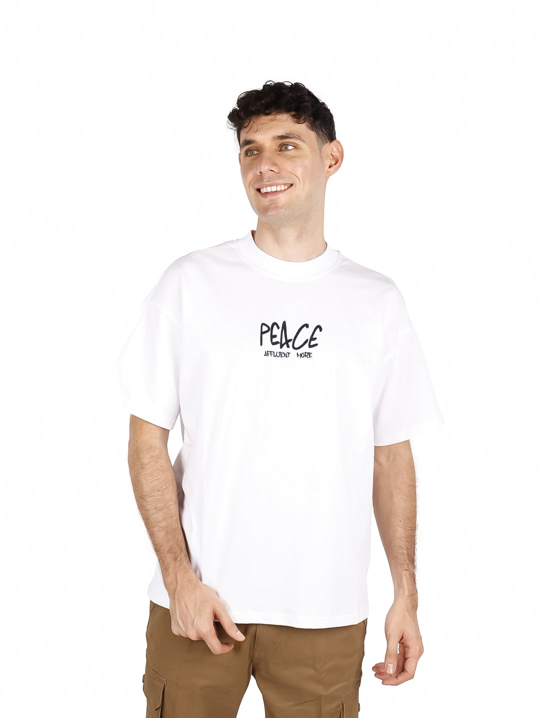 Hombre vistiendo playera blanca oversize de manga corta con estampado negro en el pecho.