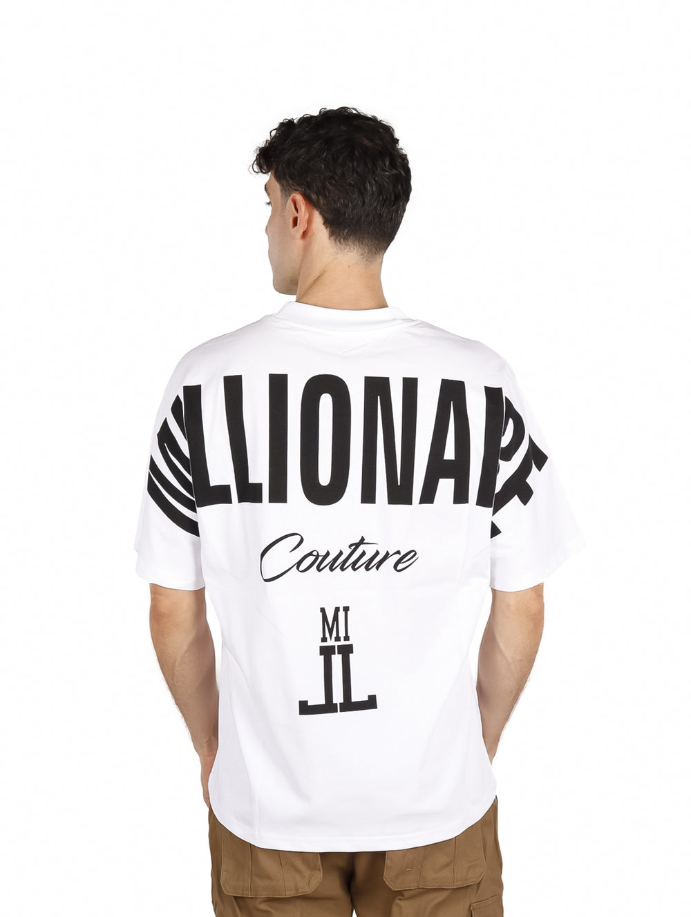 Hombre vistiendo una playera blanca oversize de manga corta con texto en el pecho.