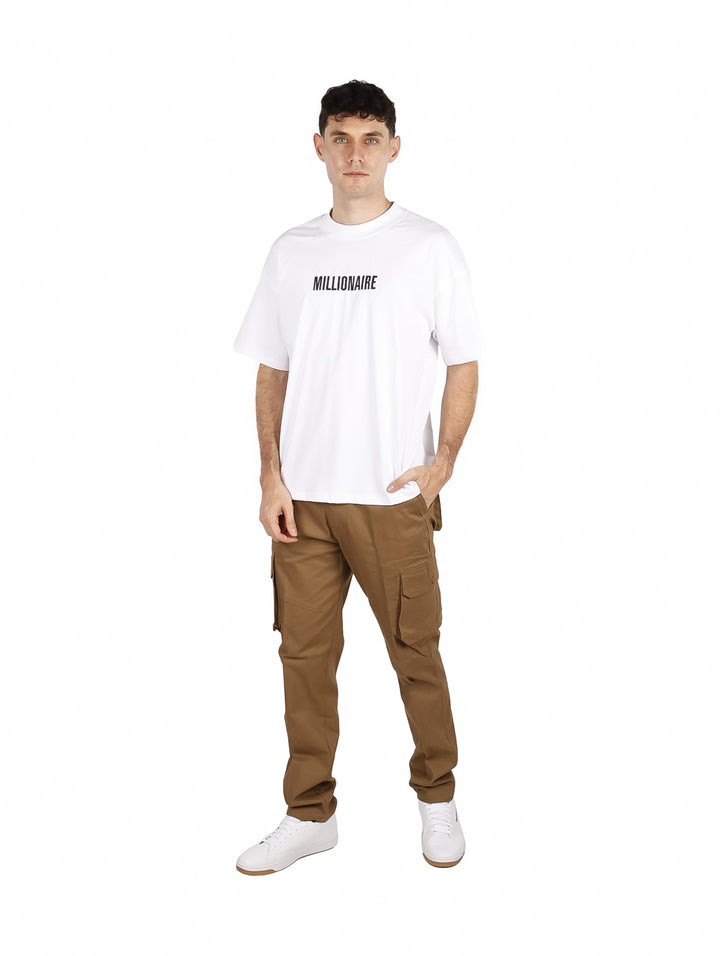 Hombre vistiendo una playera blanca oversize de manga corta con texto en el pecho.