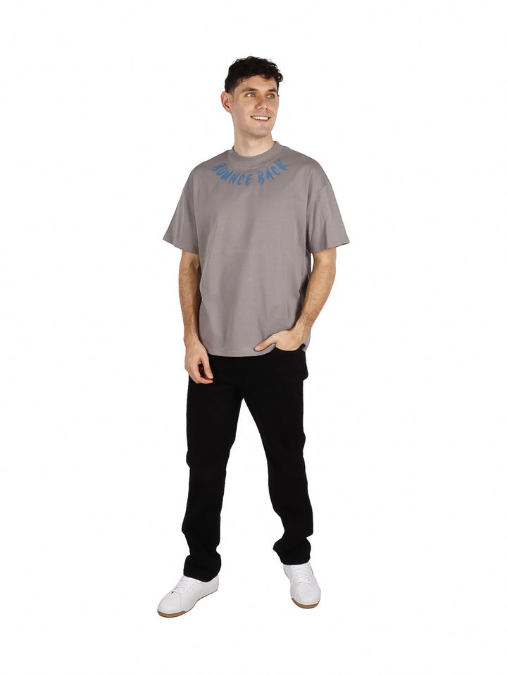 Hombre vistiendo playera gris de manga corta con texto azul &