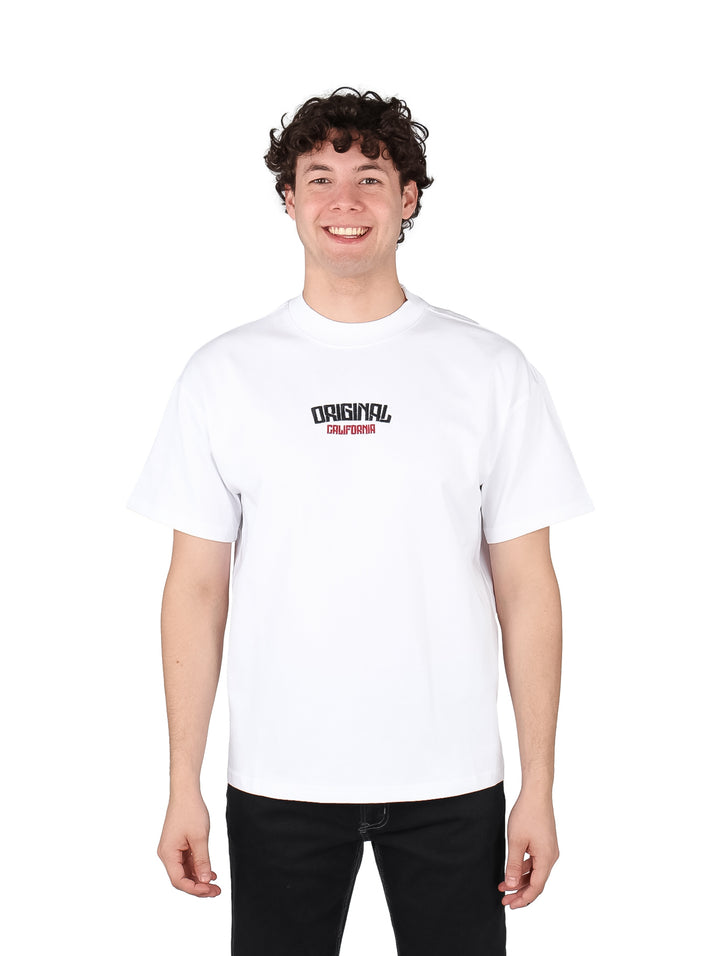 Hombre vistiendo playera blanca oversize de manga corta con estampado en el pecho.