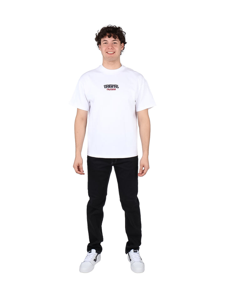 Hombre vistiendo playera blanca oversize de manga corta con estampado en el pecho.