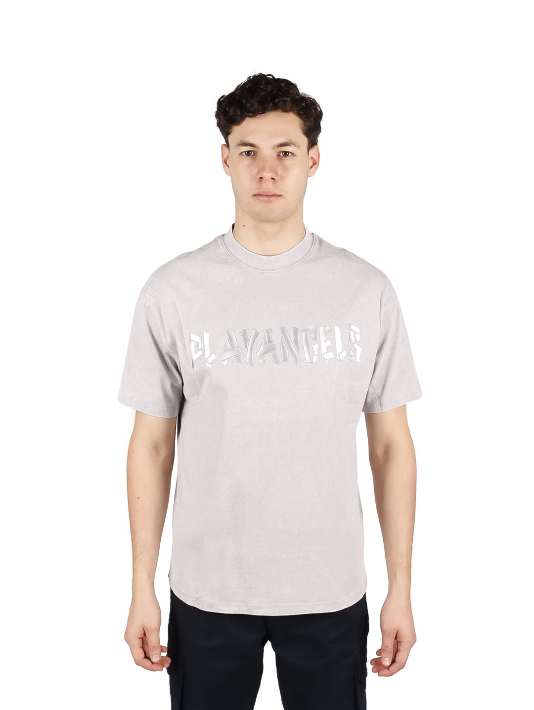 Hombre vistiendo playera oversize color gris con letras blancas en el pecho y cuello redondo.