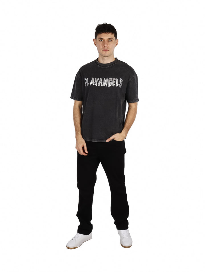 Hombre vistiendo playera oversize color negro con estampado frontal blanco.
