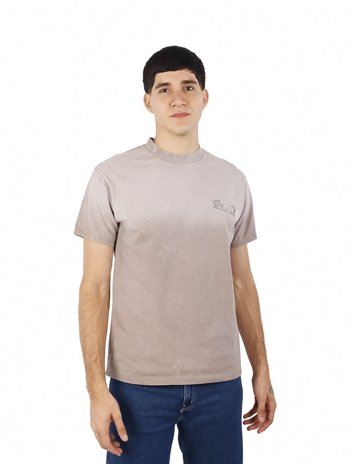 Hombre vistiendo playera oversize de color café con cuello redondo y manga corta.