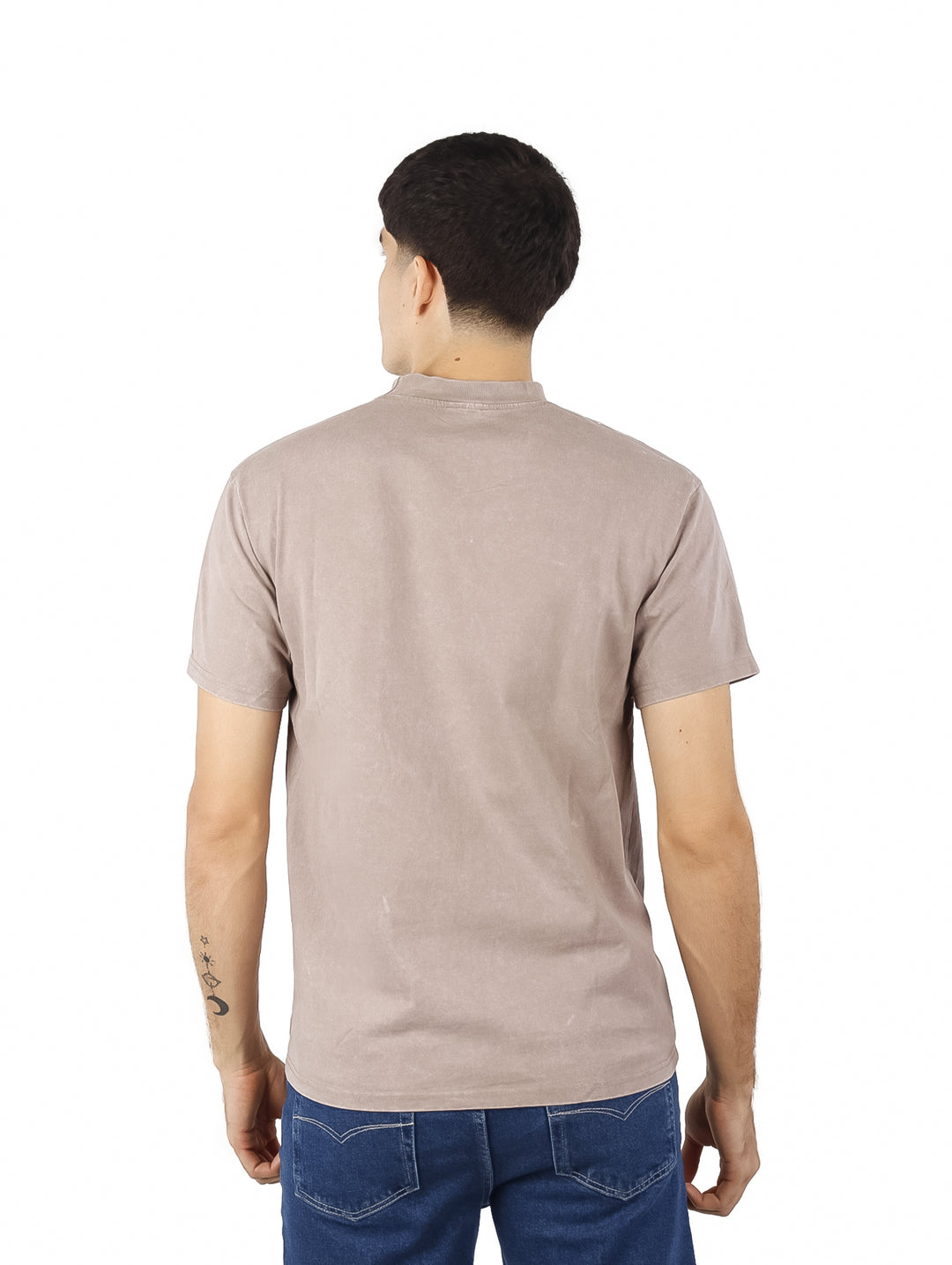 Hombre vistiendo playera oversize de color café con cuello redondo y manga corta.