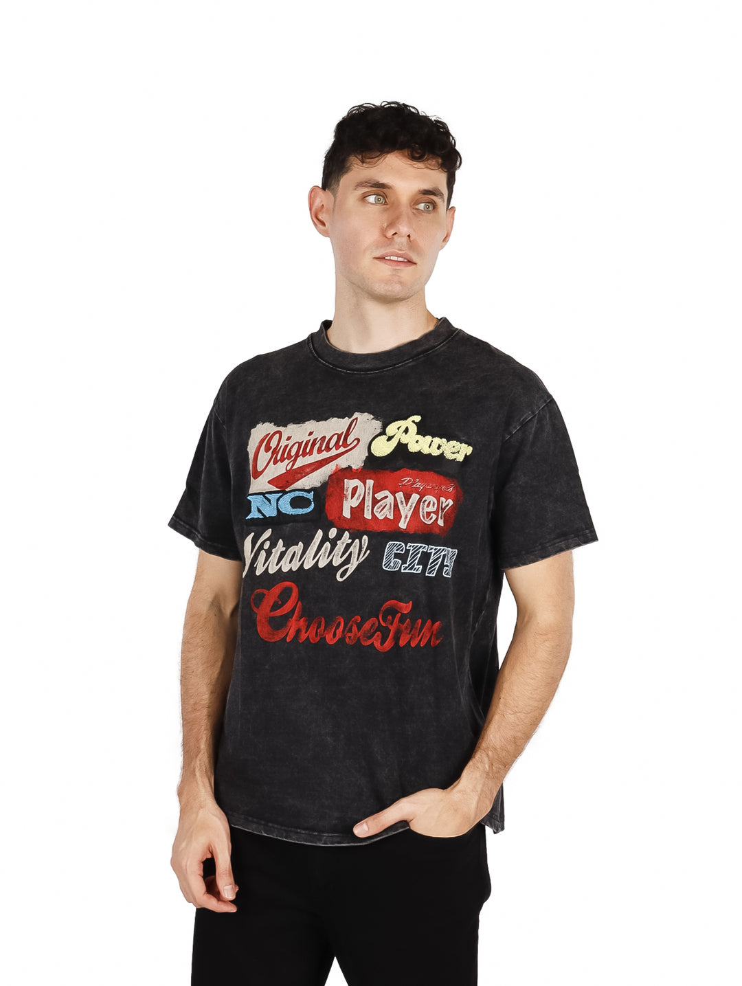 Hombre vistiendo playera oversize color negro con estampado colorido en el pecho.