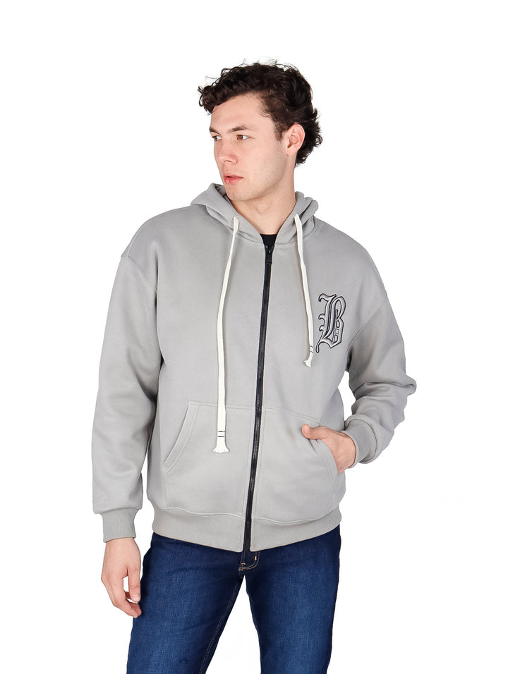 Hombre vistiendo sudadera con cierre color gris con capucha y cordones blancos.