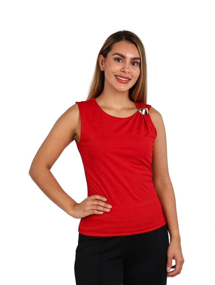 Mujer vistiendo blusa roja sin mangas con un detalle metálico plateado en el hombro.