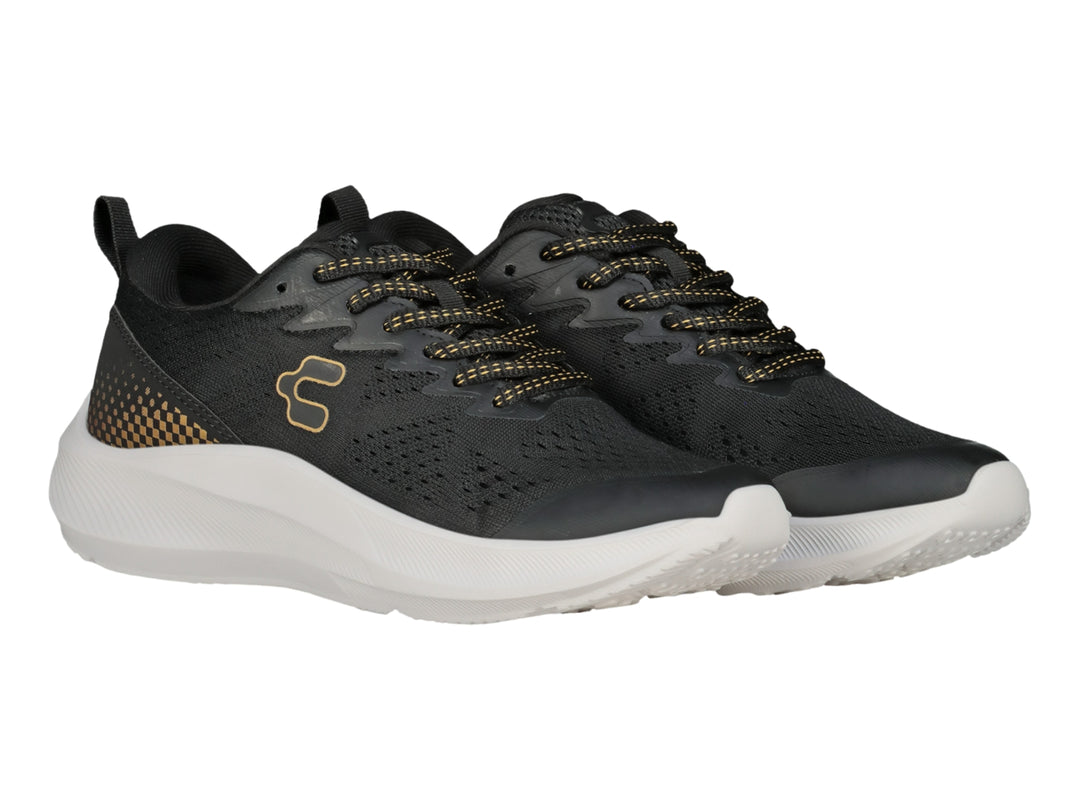 Tenis deportivos Charly color negro con detalles en oro y suela blanca gruesa.