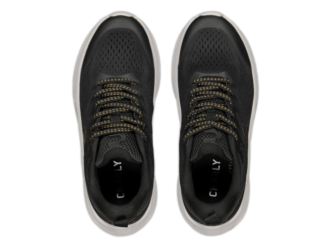 Tenis deportivos Charly color negro con detalles en oro y suela blanca gruesa.