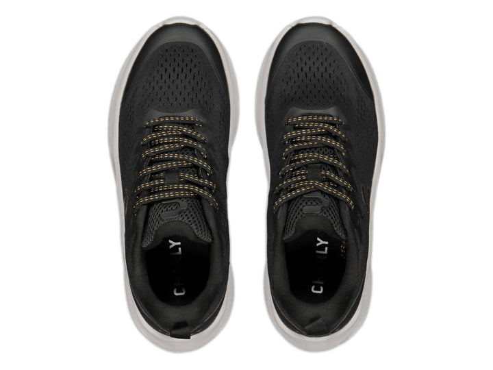 Tenis deportivos Charly color negro con detalles en oro y suela blanca gruesa.