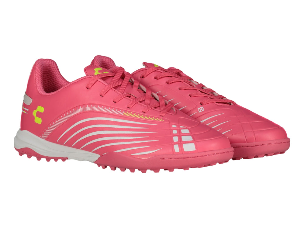Zapato de fútbol Charly color rosa con detalles blancos y suela para césped sintético.
