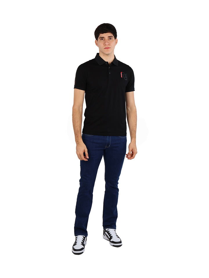 Hombre vistiendo una playera polo color negro de marca Pavini y jeans azules.