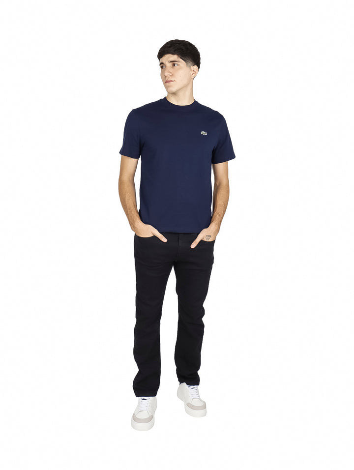 Hombre vistiendo una camiseta de manga corta color navy de la marca Lacoste con cuello redondo.