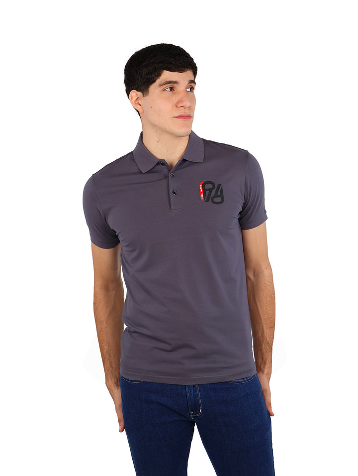 Hombre vistiendo playera polo color charcoal de la marca Pavini y pantalones azules.