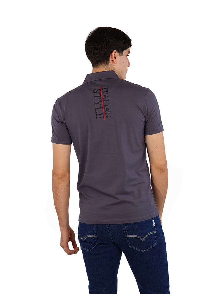 Hombre vistiendo playera polo color charcoal de la marca Pavini y pantalones azules.