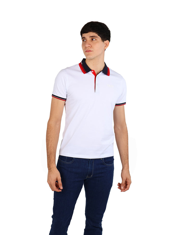 Hombre vistiendo una playera polo blanca con detalles en rojo y azul marino en el cuello y mangas.