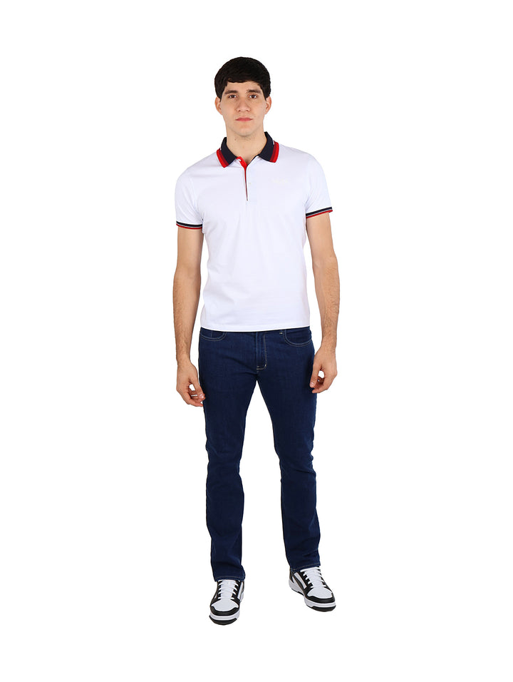 Hombre vistiendo una playera polo blanca con detalles en rojo y azul marino en el cuello y mangas.