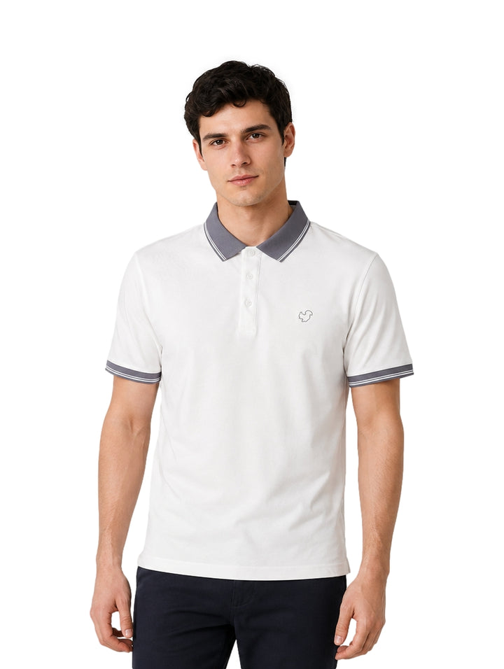 Hombre vistiendo playera polo blanca con detalles en gris en el cuello y los bordes de las mangas.
