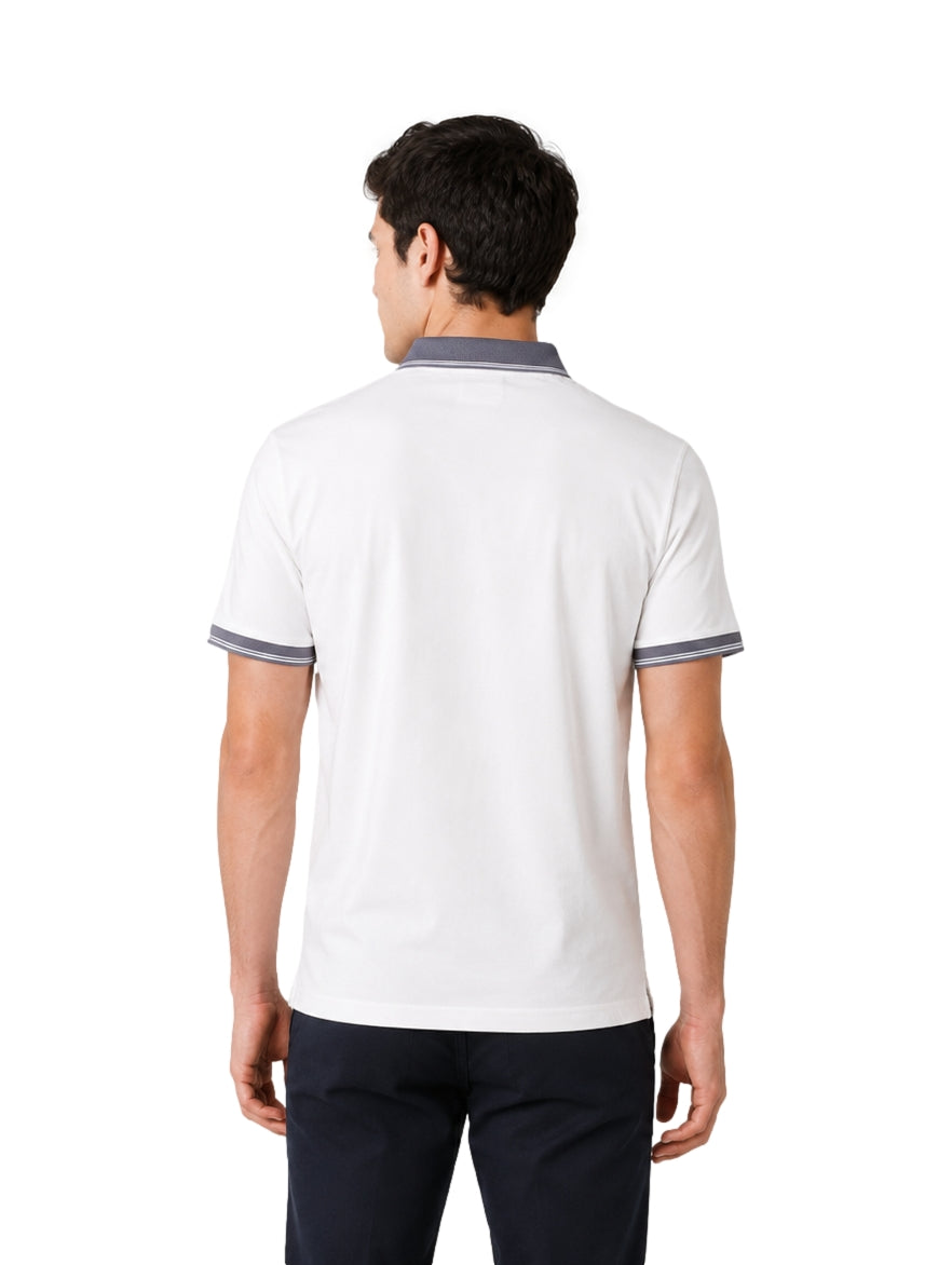 Hombre vistiendo playera polo blanca con detalles en gris en el cuello y los bordes de las mangas.