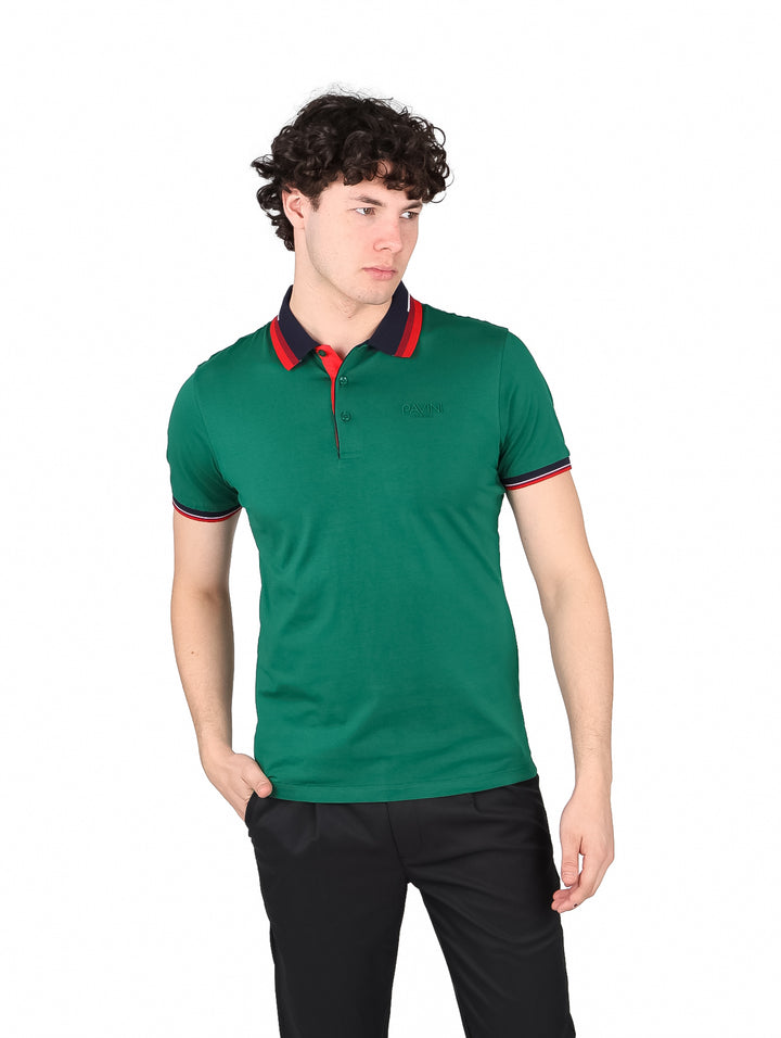 Hombre vistiendo playera polo color verde con detalles en rojo y azul marino en el cuello y mangas.