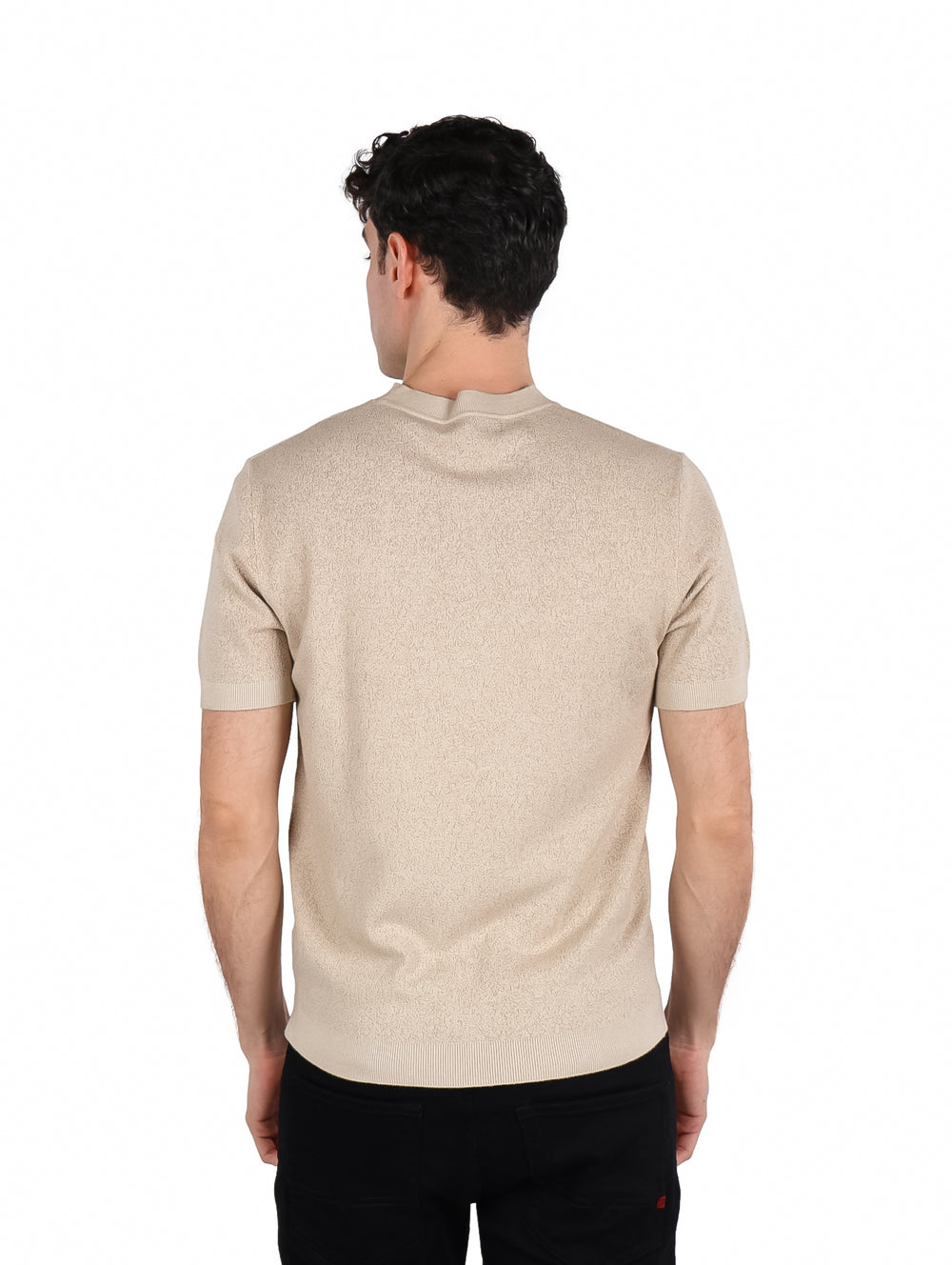 Hombre vistiendo una playera de manga corta color beige con cuello redondo y textura gruesa.