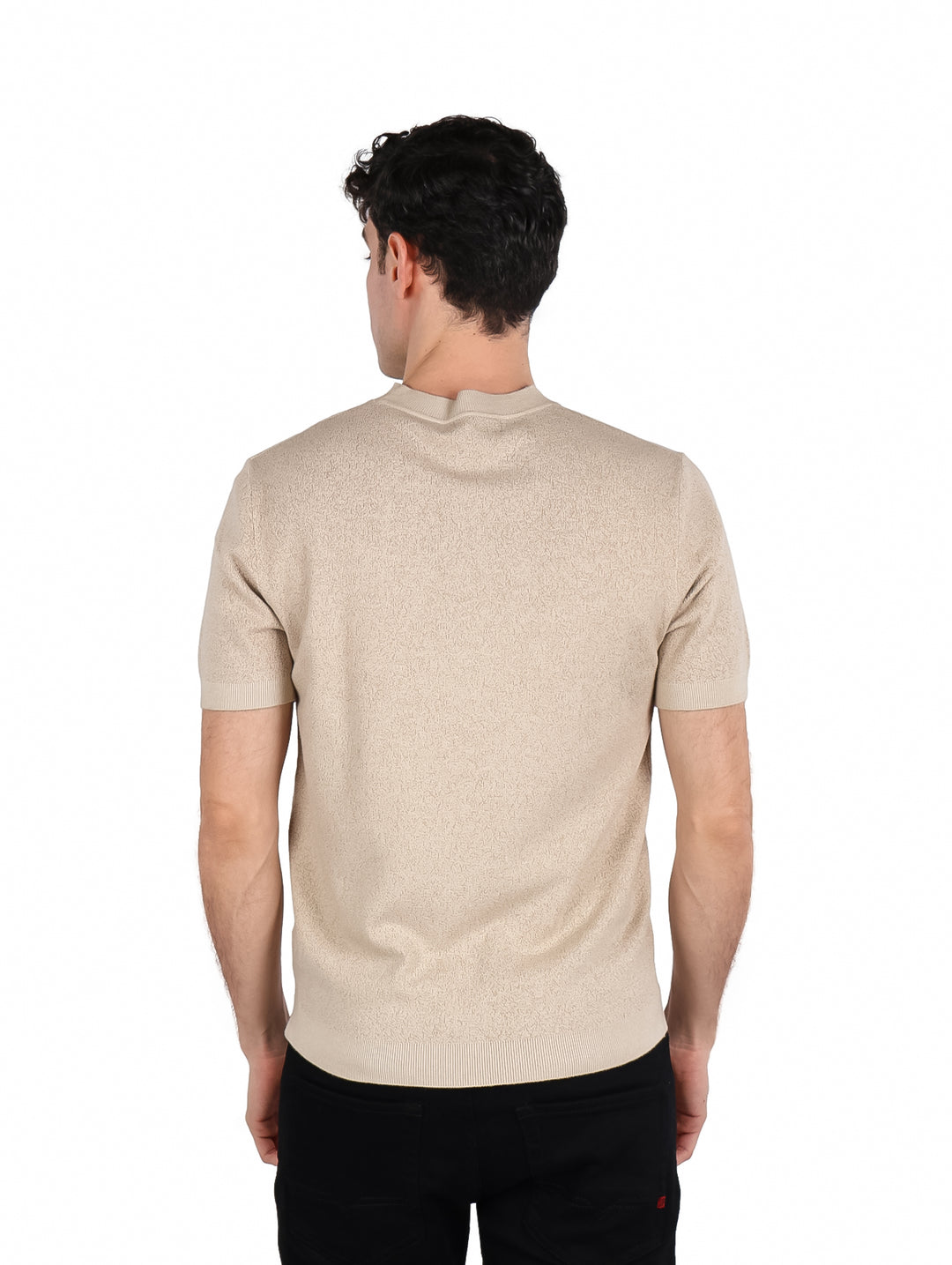 Hombre vistiendo una playera de manga corta color beige con cuello redondo y textura gruesa.