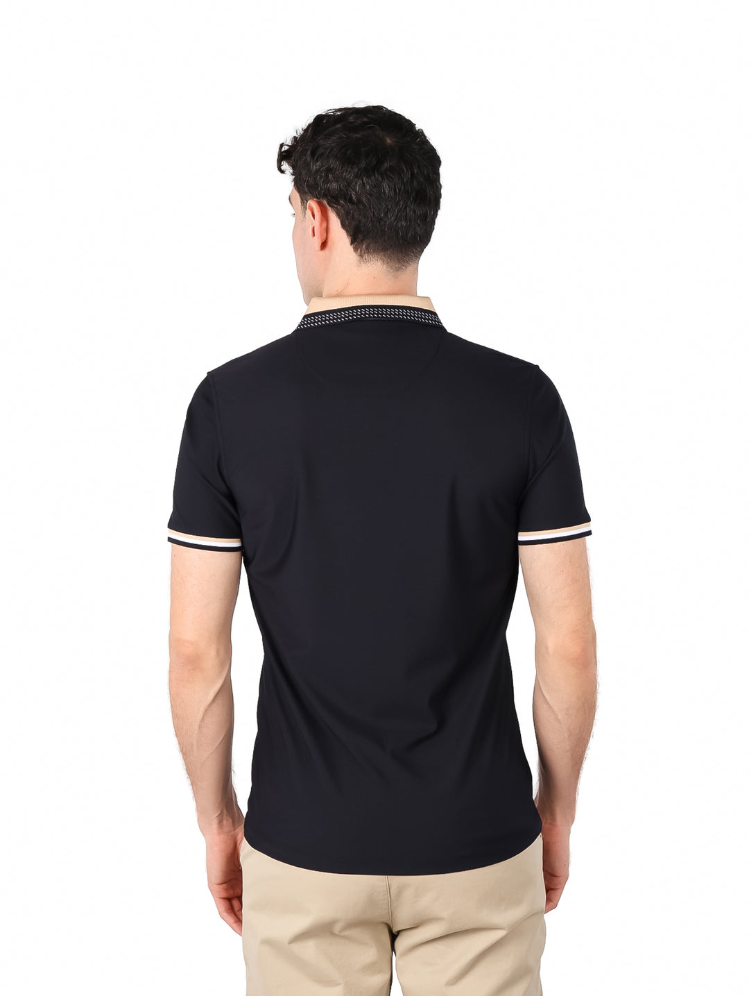 Hombre vistiendo playera polo color negro con cuello estampado y detalles beige en las mangas.