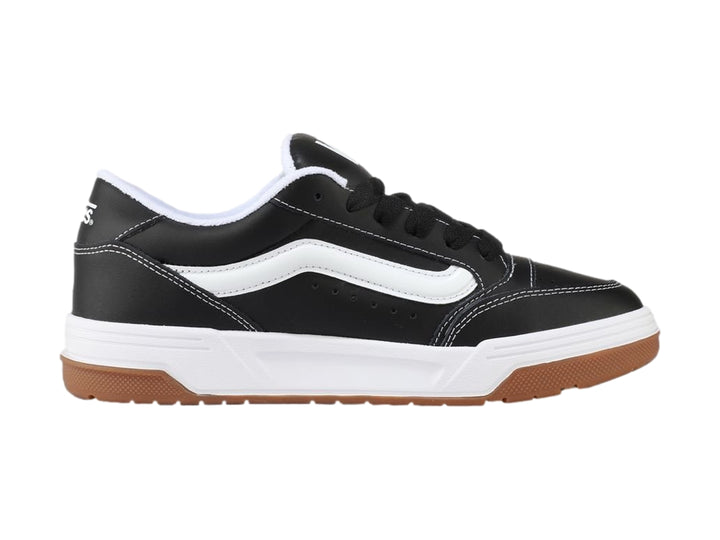 Tenis Vans Hylane en color negro con franja blanca y suela de goma marrón sobre fondo blanco.