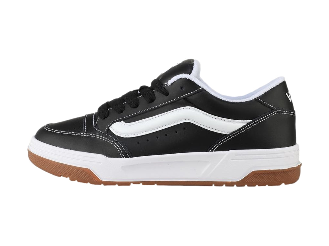 Tenis Vans Hylane en color negro con franja blanca y suela de goma marrón sobre fondo blanco.