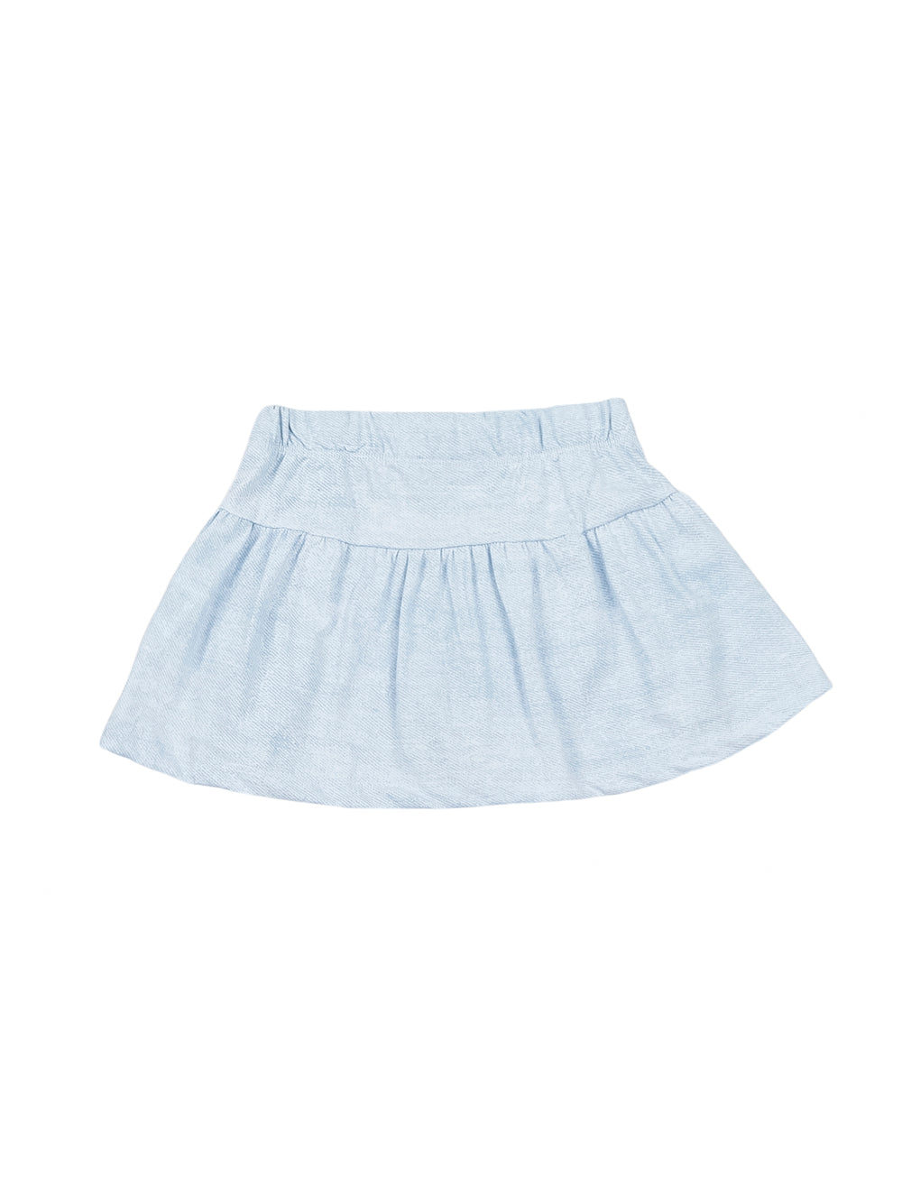 Niña pequeña vistiendo un conjunto de camiseta y falda en color azul claro con zapatos blancos.